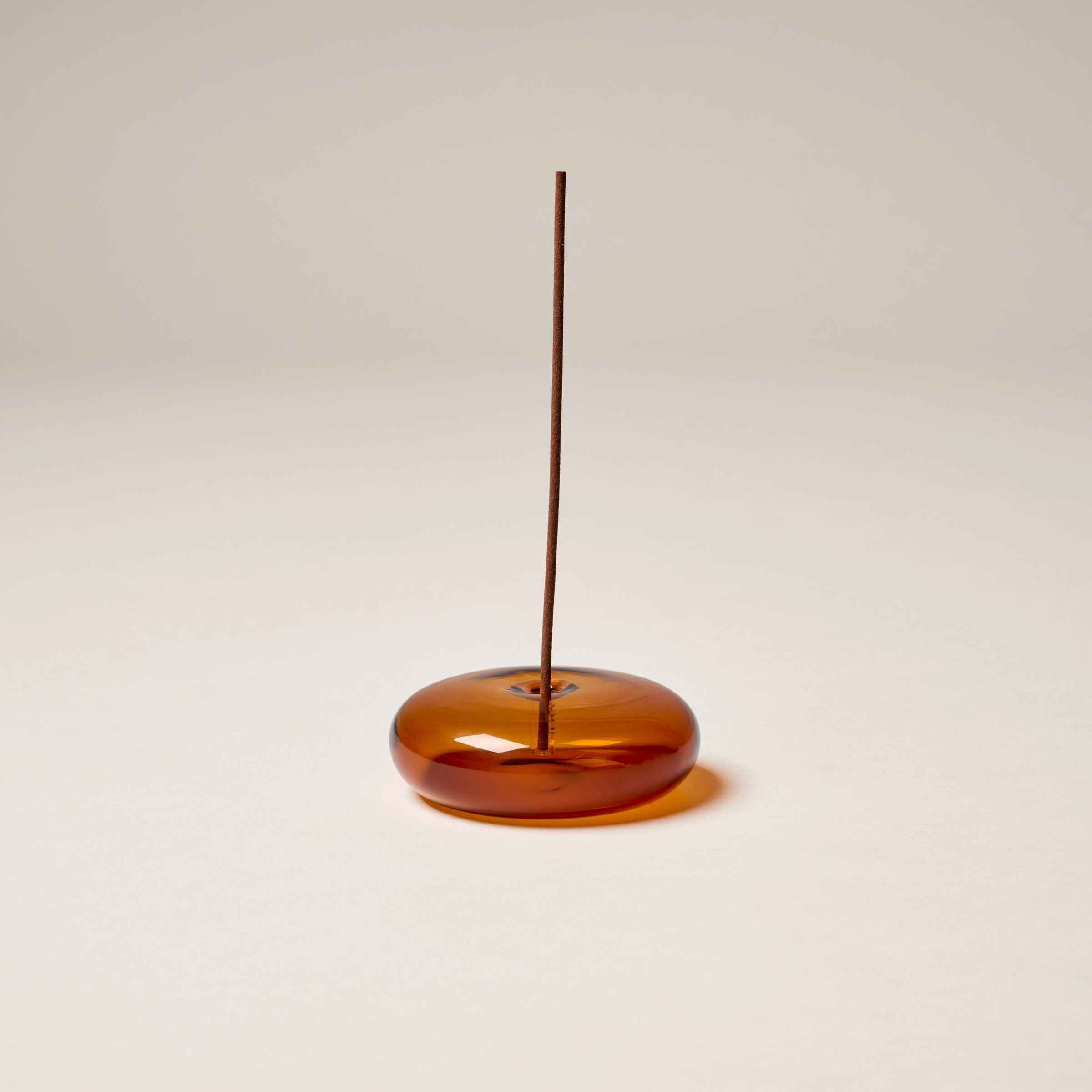 Amber glass incense holder by This is Incense with an incense stick 